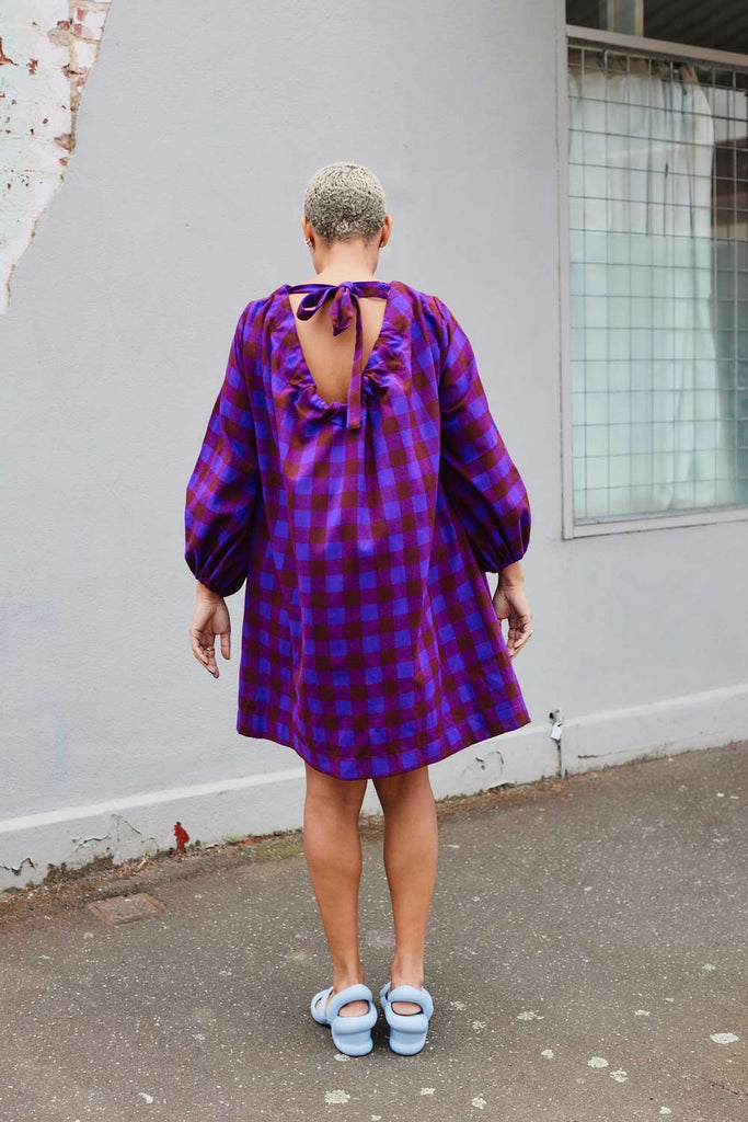 back of Collective Closets model wearing purple plaid dress maximalist design