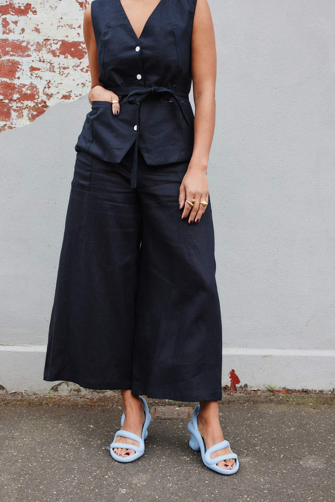 Collective Closets model in black vest and culotte pants