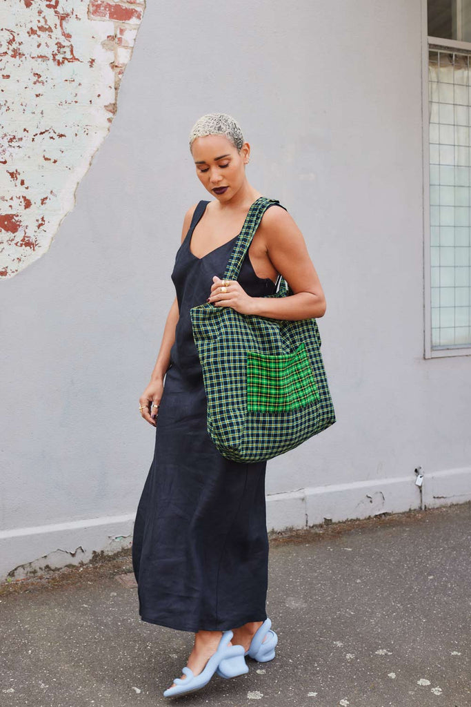 Collective Closets model hold Market lane bag and wears black linen slip dress