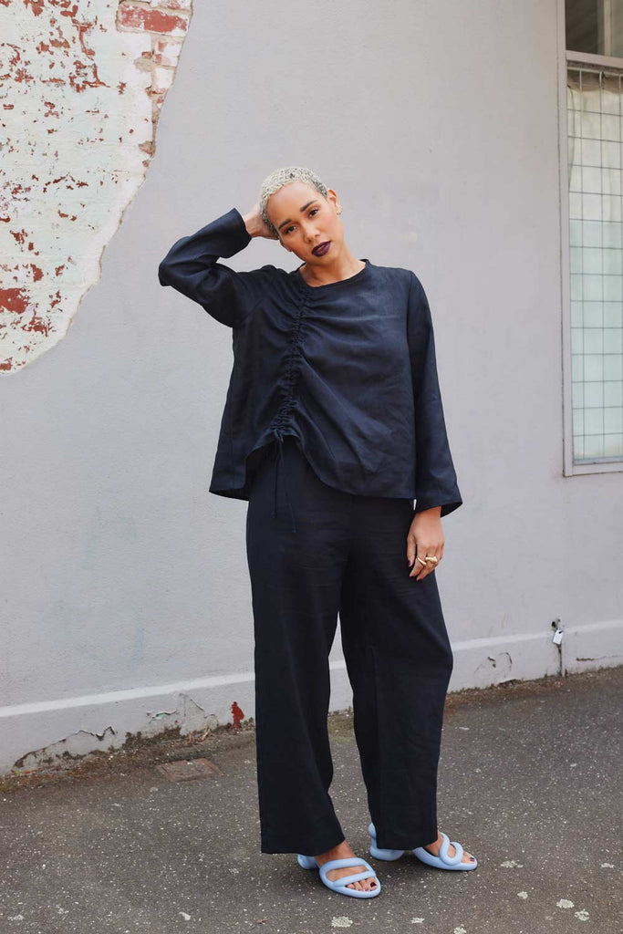 Collective Closets model wearing black linen pants and drawstring top