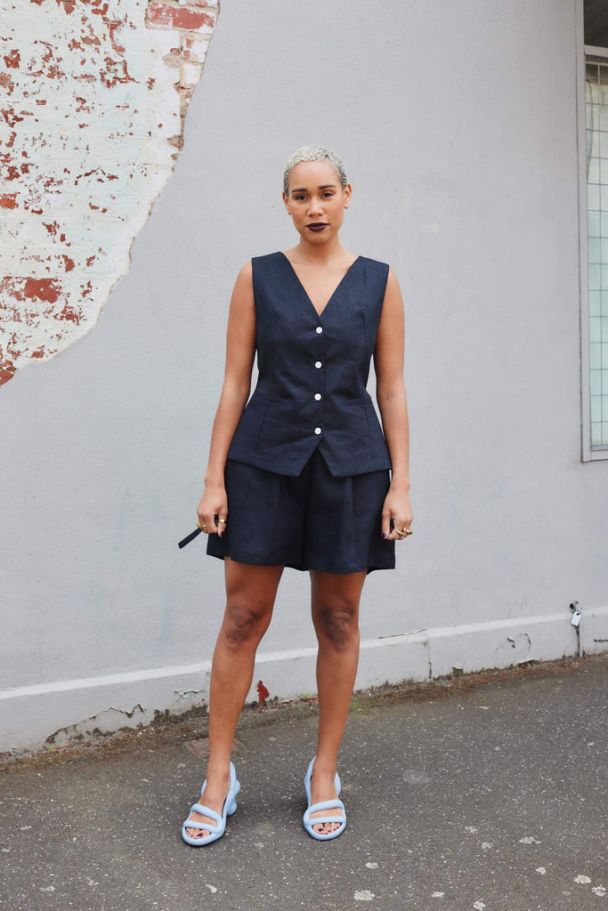 Collective Closets model in high waisted black linen shorts and Black linen vest 