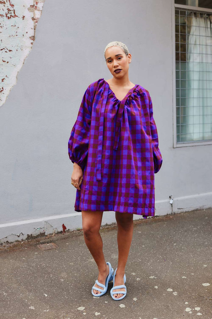 Collective Closets model in purple checkered dress