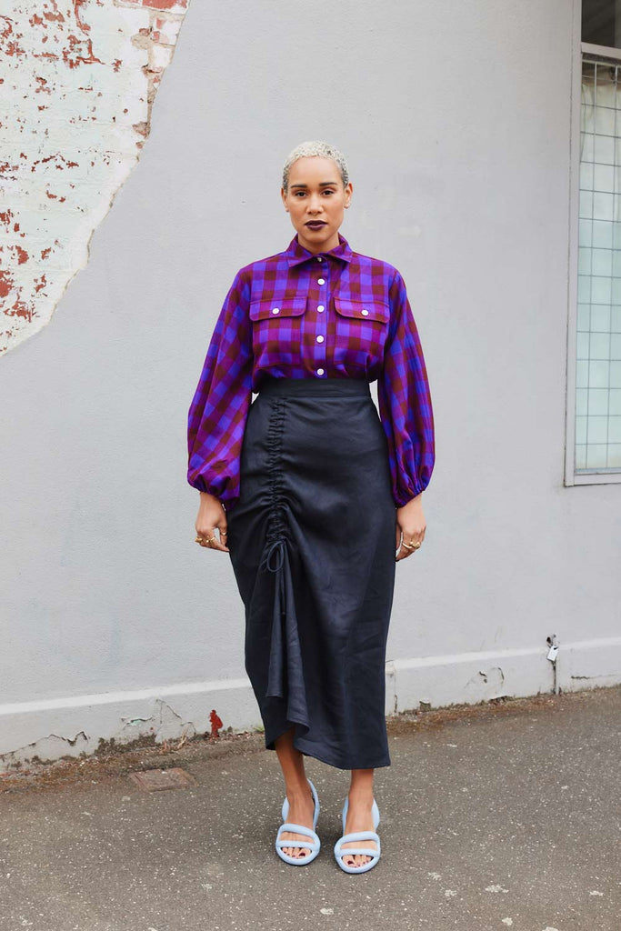 Collective Closets model wears drawstring skirt and purple shirt